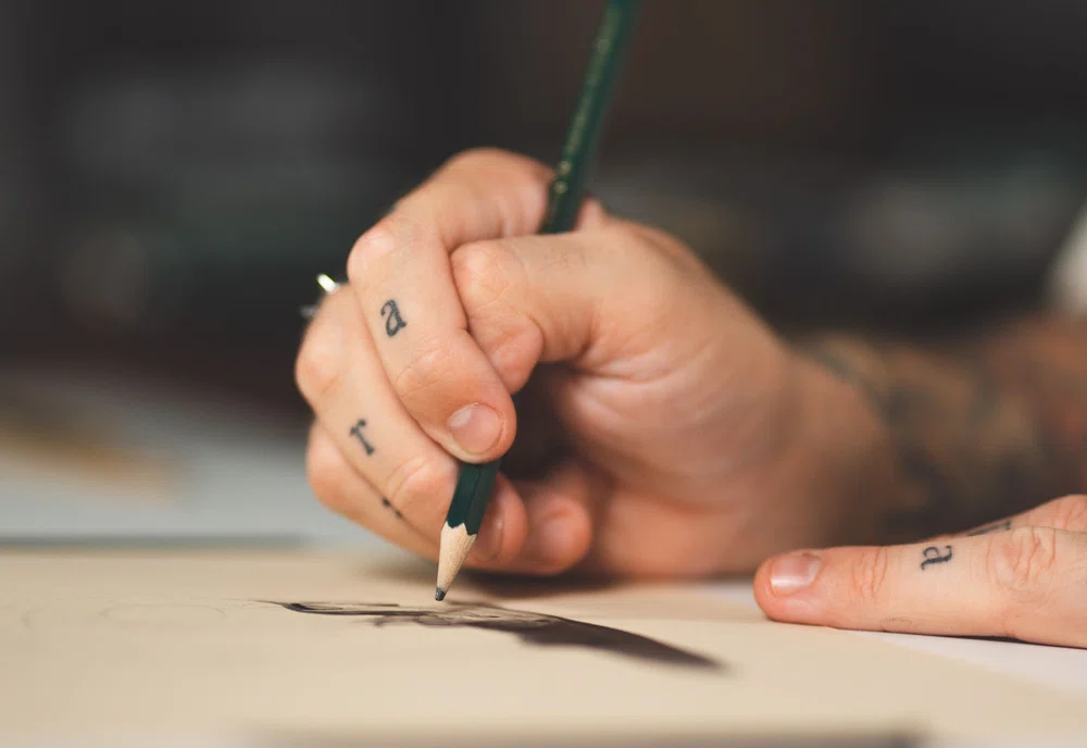 tattoo artist drawing a sketch for his tattoo portfolio